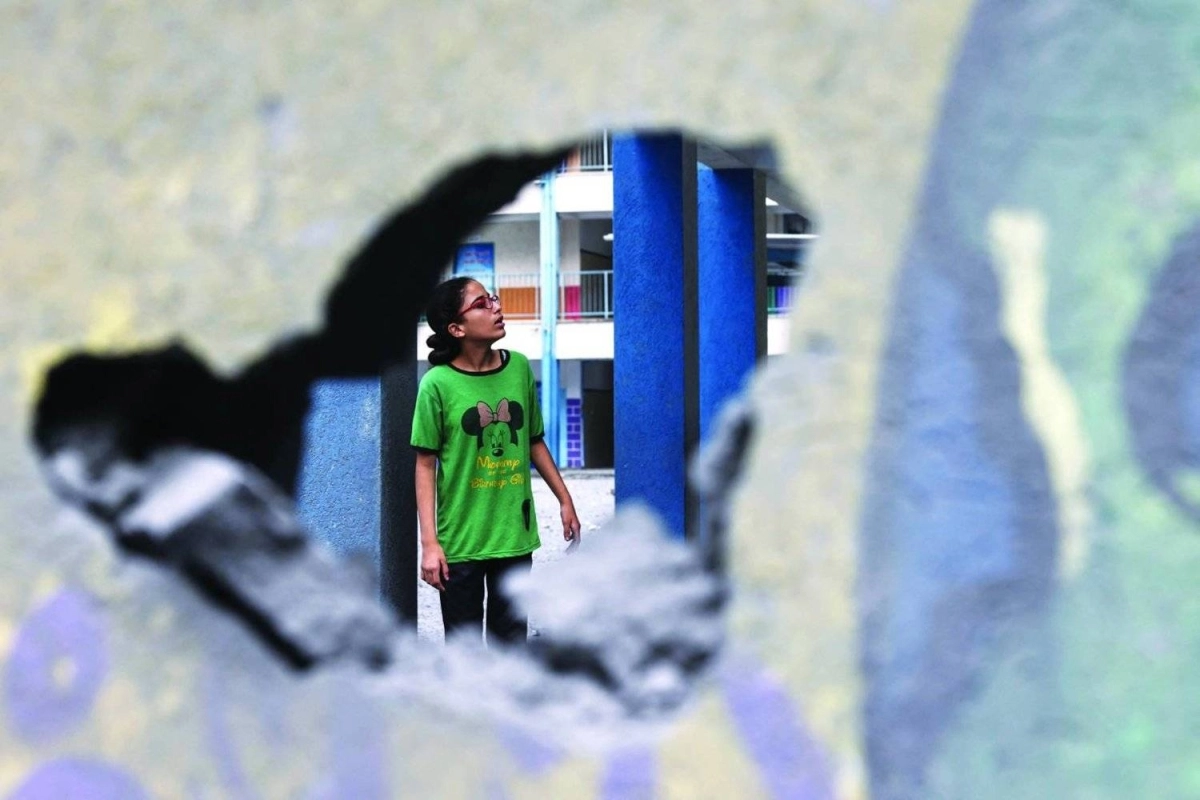 فتاة تنظر إلى مدرستها المدمرة (مكة)