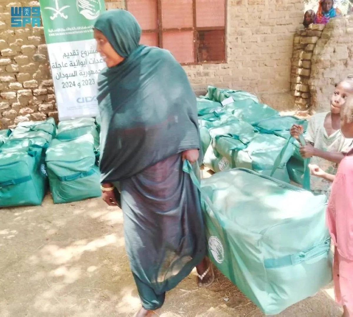 سوادنية تحمل السلة الغذائية السعودية (واس)