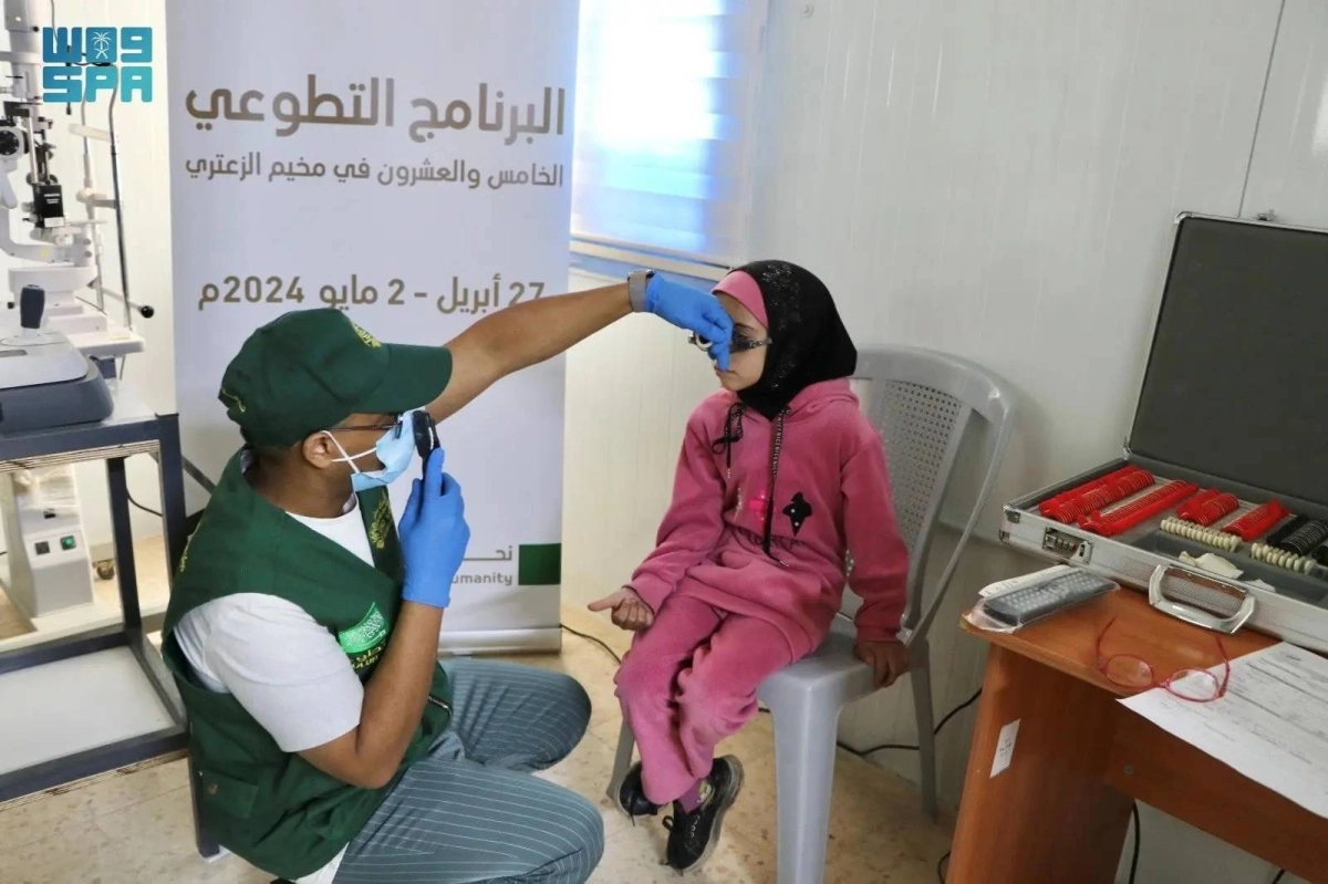 متطوع يكشف على طفلة سوية