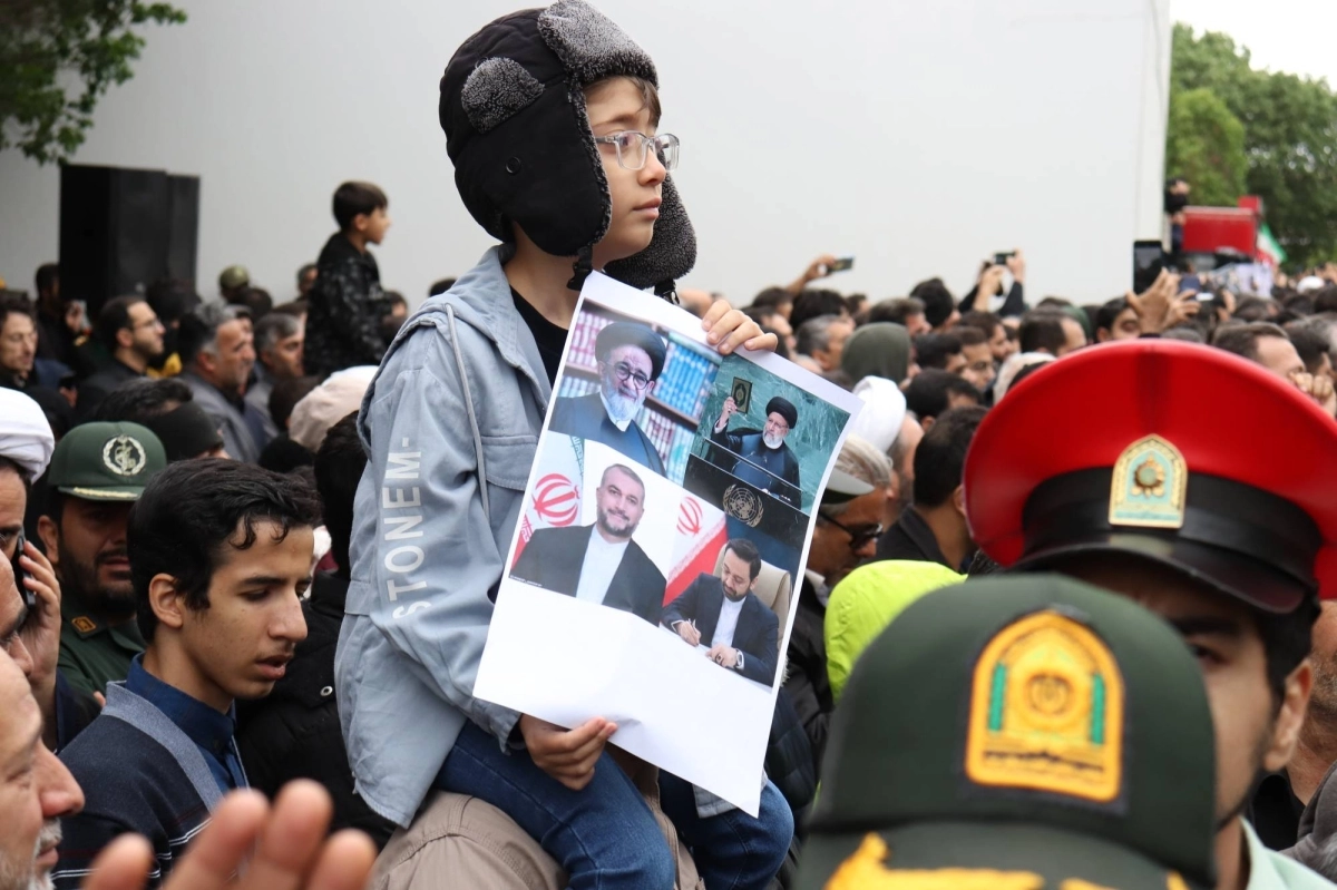 إيرانية تحمل صورة الرئيس ووزير الخارجية
