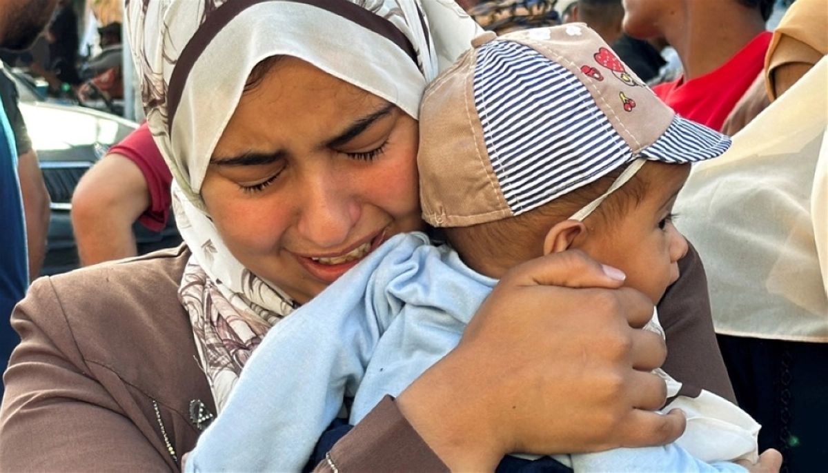 سيدة فلسطينية تحمل طفلها باكية (مكة)