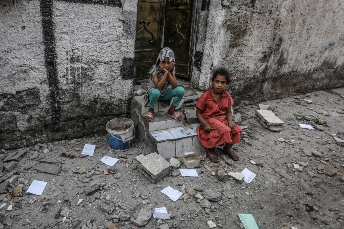 


طفلان يجلسان في حزن أمام منزلهما المدمر                                                                 (د ب أ) 