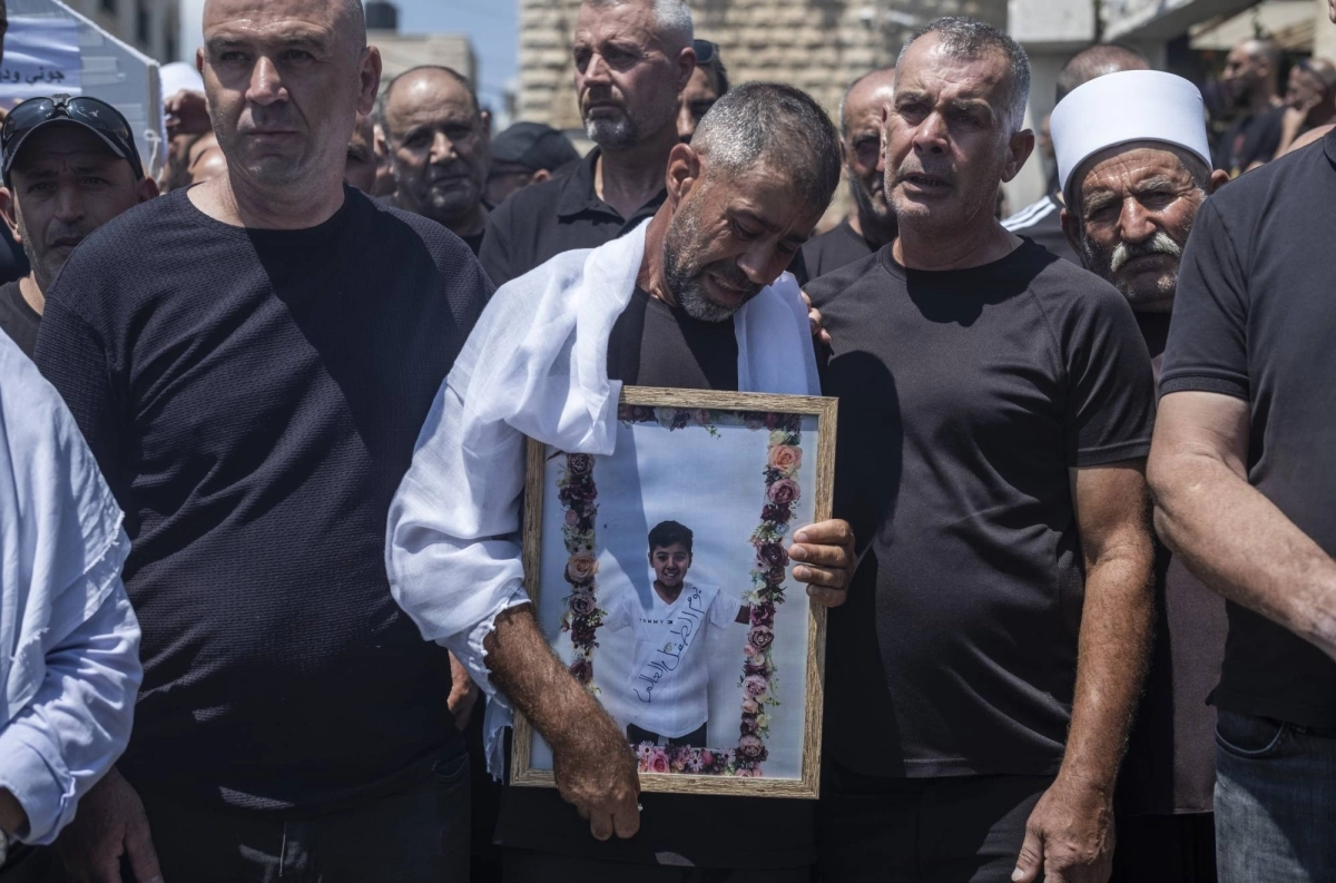 أب سوري يحمل صورة ابنه