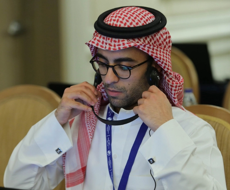إعلامي يضع سماعات الترجمة على أذنيه خلال متابعته إحدى الجلسات (محمد مشهور)