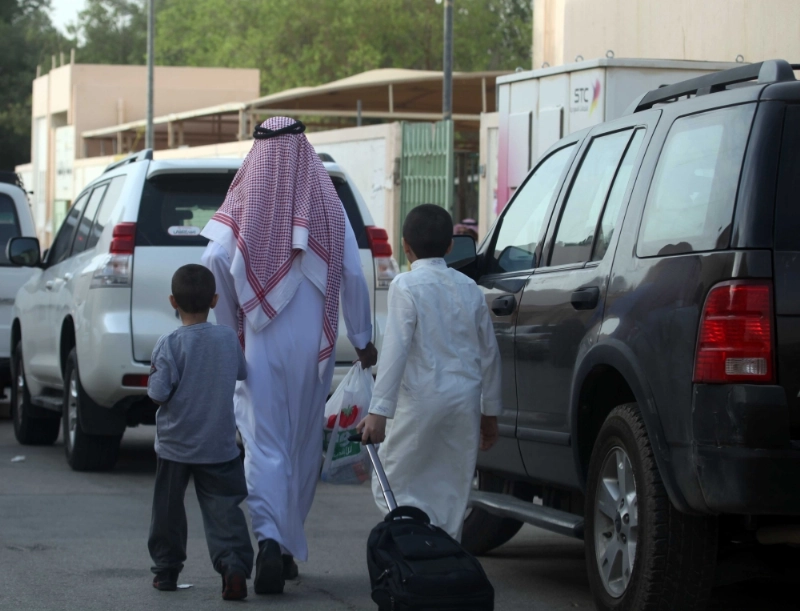 ولي أمر يوصل طفليه إلى مدرستهما (مكة)