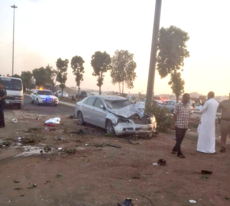 رجال المرور لحظة مباشرة الحادث وتبدو جثة أحد ضحاياه (ياسر بخش)