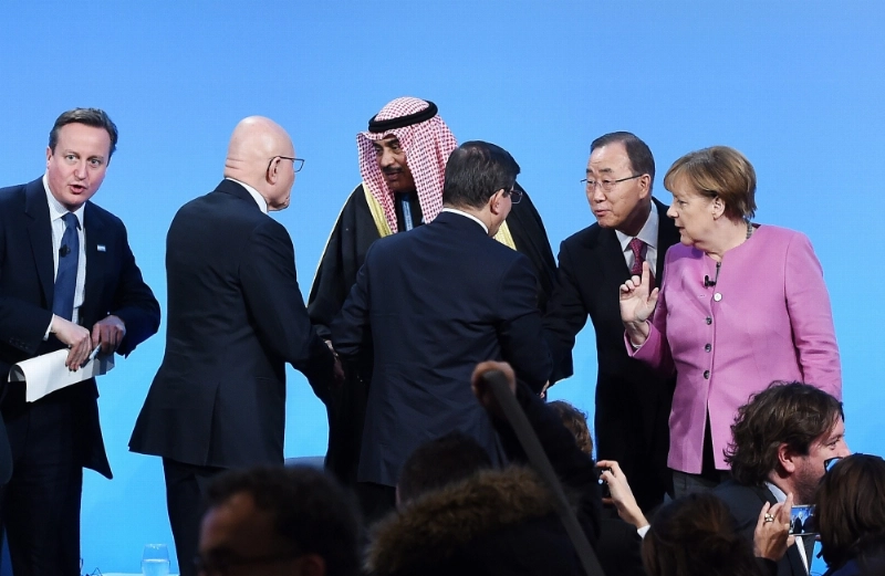 بن كي مون بجوار المستشارة الالمانية خلال مشاركتهم بمؤتمر لندن للمانحين (إ ب أ)