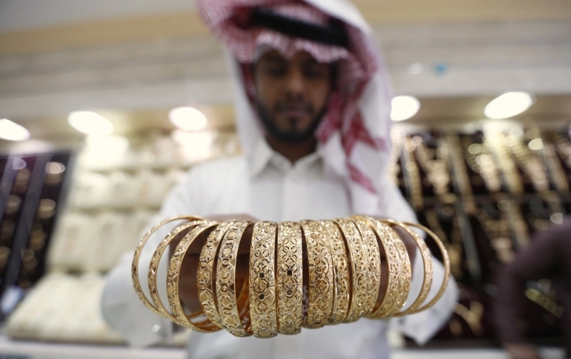 بائع يعرض مشغولات من الذهب (رويترز)