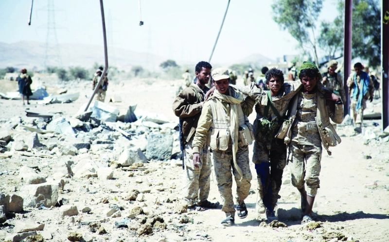 جنود من الجيش يساعدون جريحا بأحد المخيمات في نهم (أ ف ب)