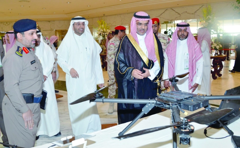 بندر المشاري مطلعا على أحد الأجهزة التقنية لقاعات الداخلية (مكة)