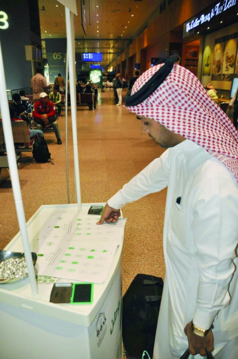 مسافر يبصم على قيم الحملة قبل مغادرته المطار (مكة)