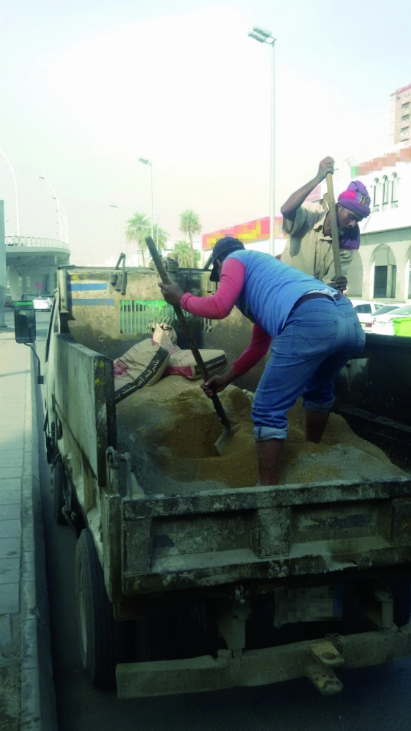 عامل يجهز الخلطة داخل حوض القلاب