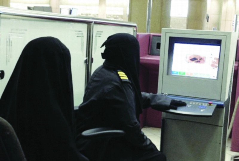 موظفة جمارك تفحص حقيبة مسافرة في مطار الملك خالد (مكة)