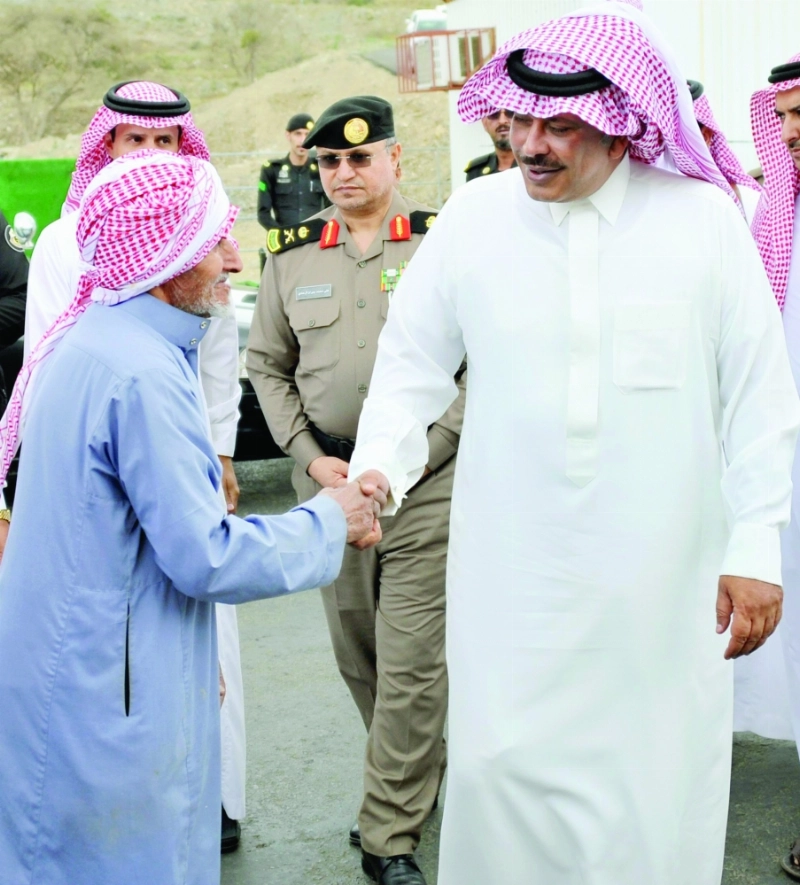 مشاري بن سعود مصافحا أحد المسنين داخل السوق (واس)