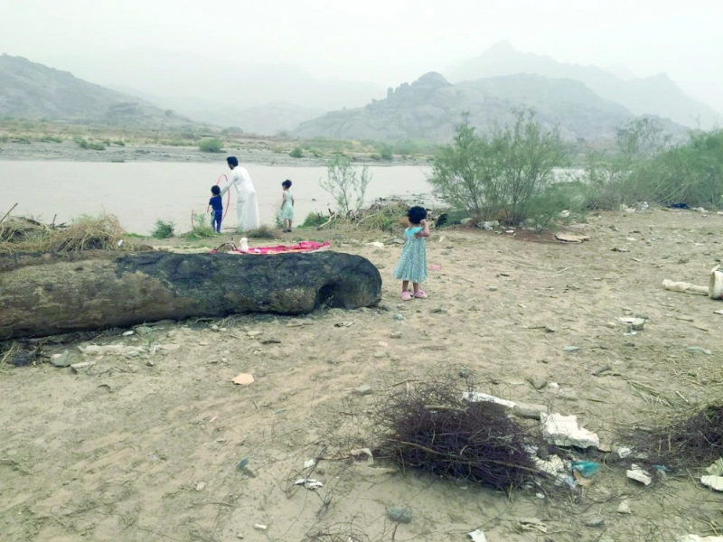 مواطن مع أطفاله بجانب أحد أودية نجران (مكة)