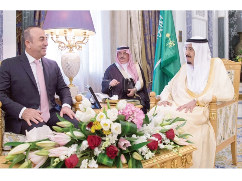 خادم الحرمين مستقبلا وزير خارجية تركيا مولود جاويش أوغلو في الرياض أمس (واس)