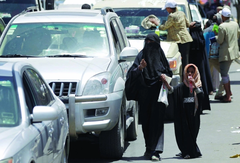 يمنية وابنتها تتسولان في ظل احتياج 80 % من الشعب جراء الانقلاب على الشرعية (أ ف ب)
