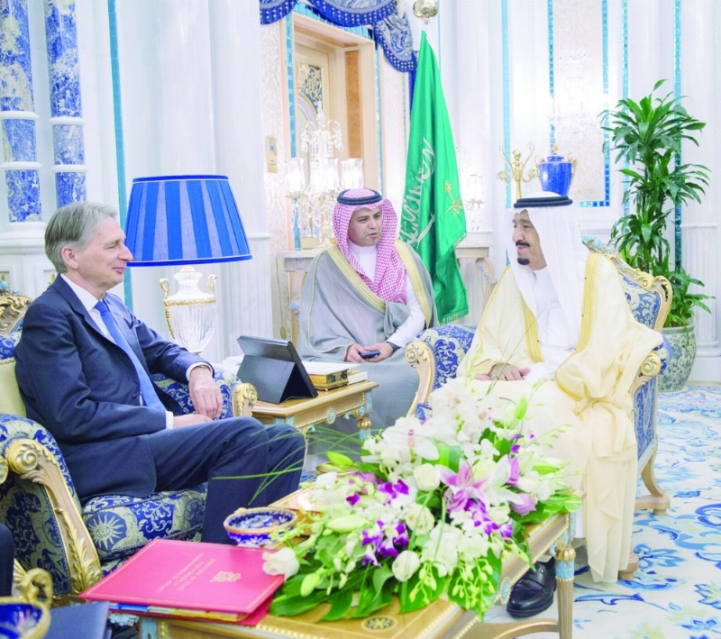 الملك سلمان مستقبلا فيليب هاموند والوفد المرافق له بقصر السلام أمس (واس)