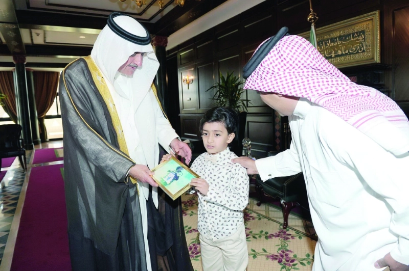 فهد بن سلطان خلال لقائه بالطفل ووالده (مكة)