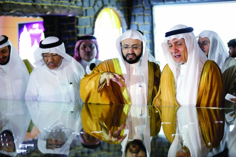 تركي الفيصل مستمعا لشرح عن المعرض (محمد عطية)