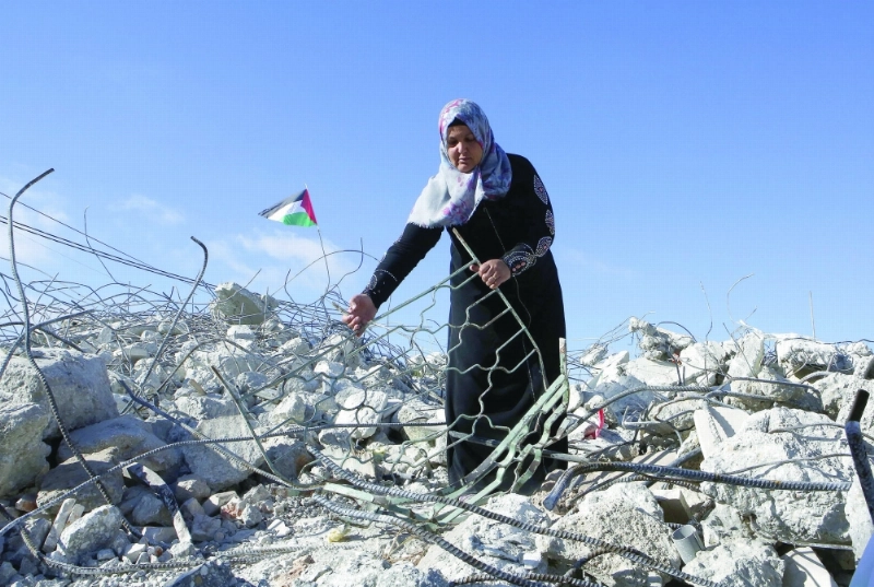 فلسطينية أمام أنقاض منزل دمره الاحتلال في يطا بالضفة (إ ب أ)