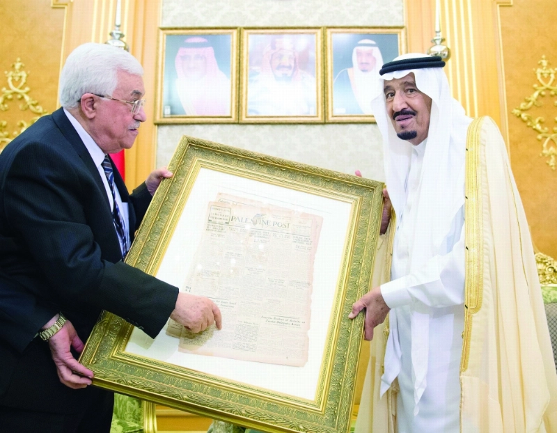 الملك سلمان لدى تسلمه هدية تذكارية من محمود عباس