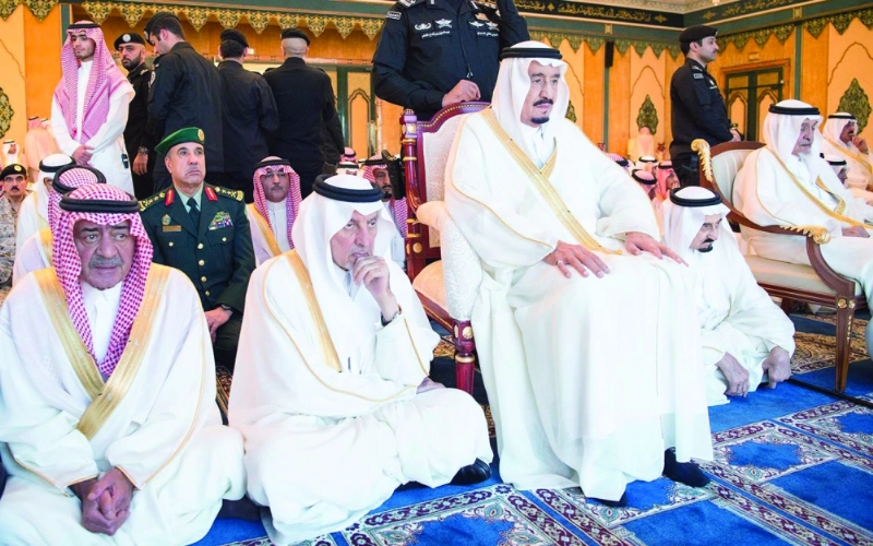 خادم الحرمين لدى أدائه صلاة العيد وإلى جانبه الأميران خالد الفيصل ومقرن بن عبدالعزيز (واس)