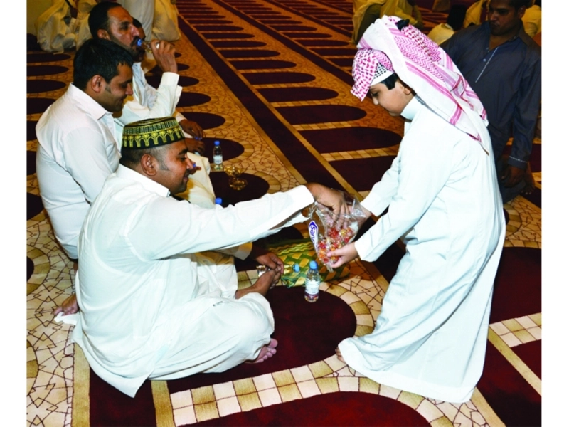 طفل يوزع الحلوى على المصلين في جامع الراجحي بمكة (عبدالمحسن دومان)