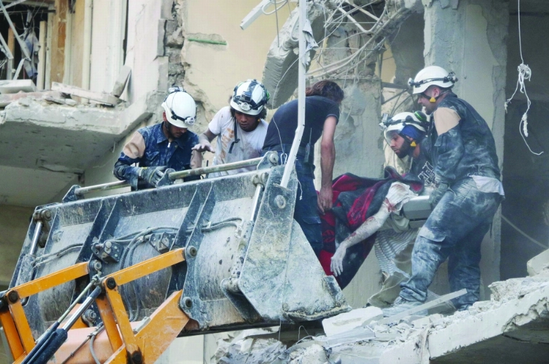 رجال إنقاذ ينتشلون جثمان رجل من بين الأنقاض عقب غارة بحلب (أ ف ب)