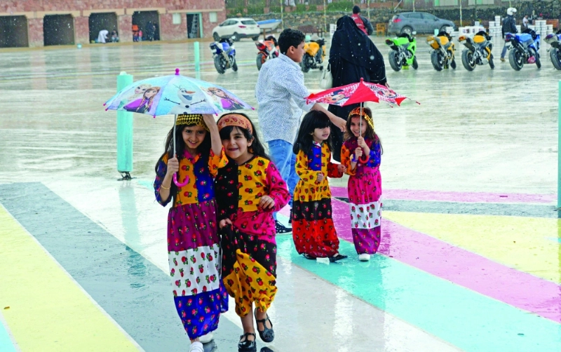 أطفال في لحظة مرح خلال الأجواء الماطرة (واس)