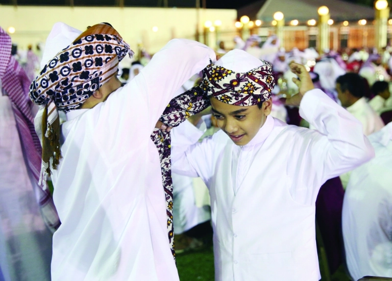 شخص يعلم لف العمامة لأحد الأطفال (مكة)