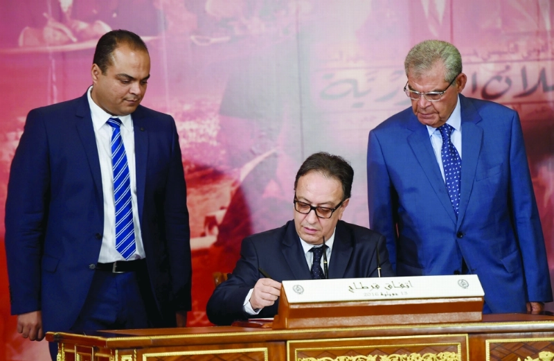 ممثل حزب نداء تونس يوقع الوثيقة الجديدة أمس (أ ف ب)