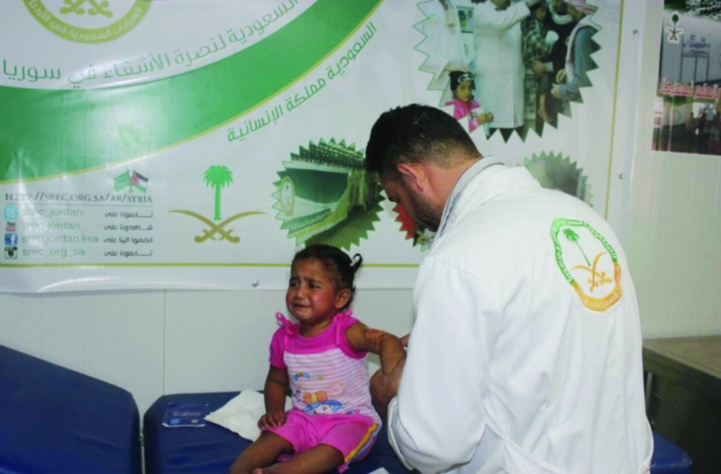 طبيب سعودي يعالج طفلة سورية بمخيم الزعتري (واس)