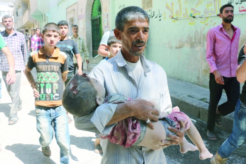 سوري يحمل جثمان نجله الذي قتل بغارة للنظام في حلب (أ ف ب)