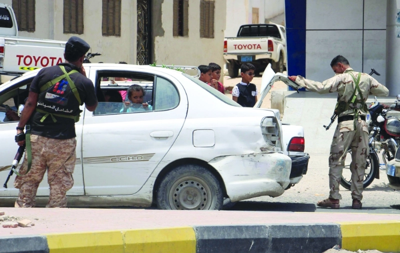 جنود يفتشون سيارات في نقطة تفتيش بالمكلا (أ ف ب)