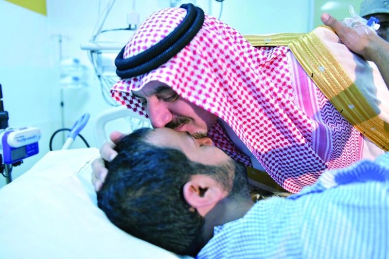 جلوي بن عبدالعزيز يقبل رأس جندي خلال زيارته مصابي الحد الجنوبي (واس)