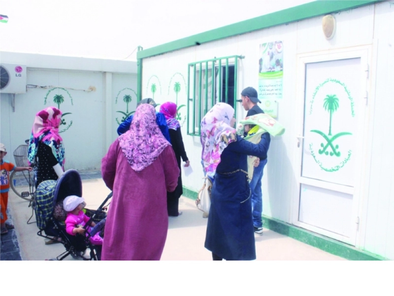 سوريون أمام صيدلية العيادات السعودية بالزعتري (واس)