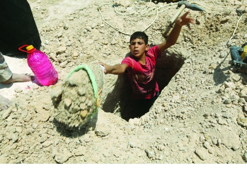 صبي يحفر قبرا جنوب بغداد (رويترز)