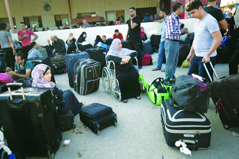 فلسطينيون ينتظرون العبور من منفذ رفح بغزة إلى القاهرة أمس (أ ف ب)