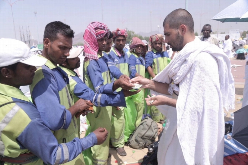 حاج على جبل الرحمة يوزع نقودا على عمال النظافة