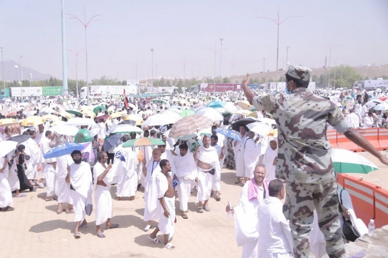 رجل أمن يوجه الحجاج على مسار الخروج من جبل الرحمة