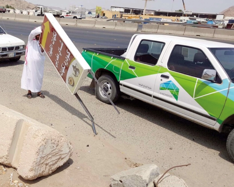 جانب من إزالة إحدى اللوحات المخالفة (مكة)