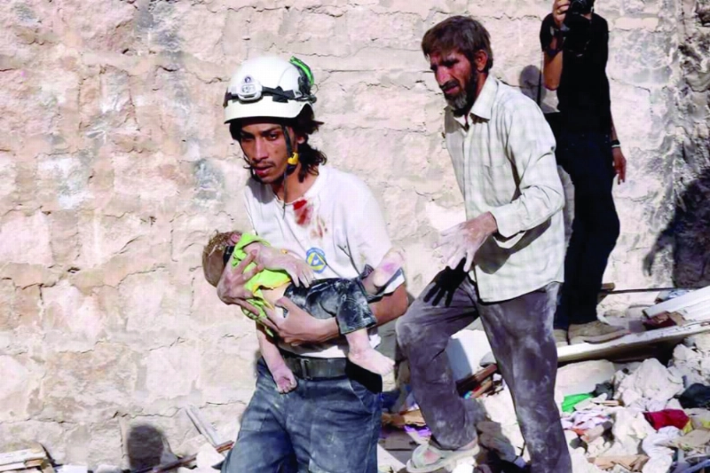 متطوعون يحملون جثة طفل عقب غارات للنظام في حلب (إ ب أ)