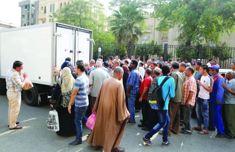 مصريون أمام منفذ لبيع السكر بالقاهرة (رويترز)
