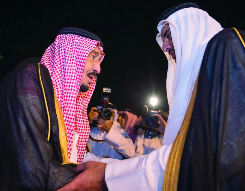 الملك سلمان مصافحا أمير قطر لدى وصوله الدوحة أمس الأول