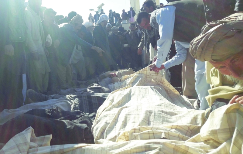 أفغان حول جثث الضحايا في جور الباكستانية (أ ف ب)