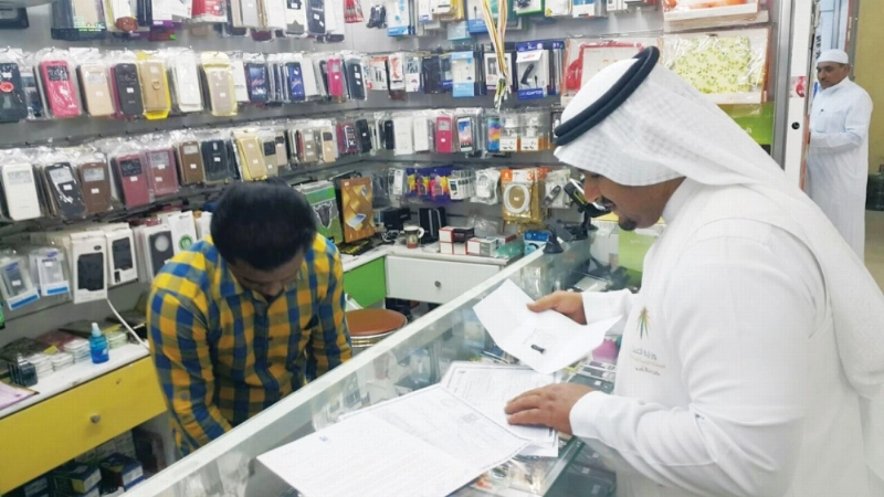 ممثل وزارة العمل أثناء التأكد من بيانات أحد المحلات (مكة)