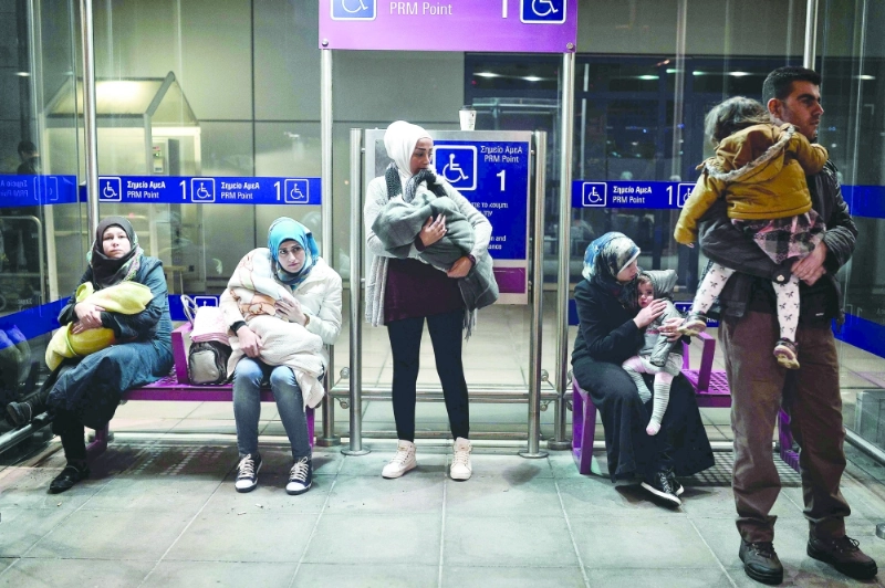 لاجئون سوريون بمطار أثينا في طريقهم إلى فرنسا (أ ف ب)