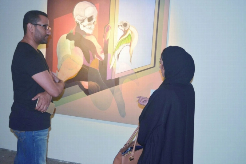 أحمد النجار يتحدث مع زائرة حول لوحة لمحمد ظاظا (مكة)