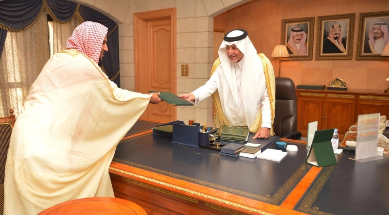 خالد الفيصل يتسلم التقرير من علي العبدلي (واس)